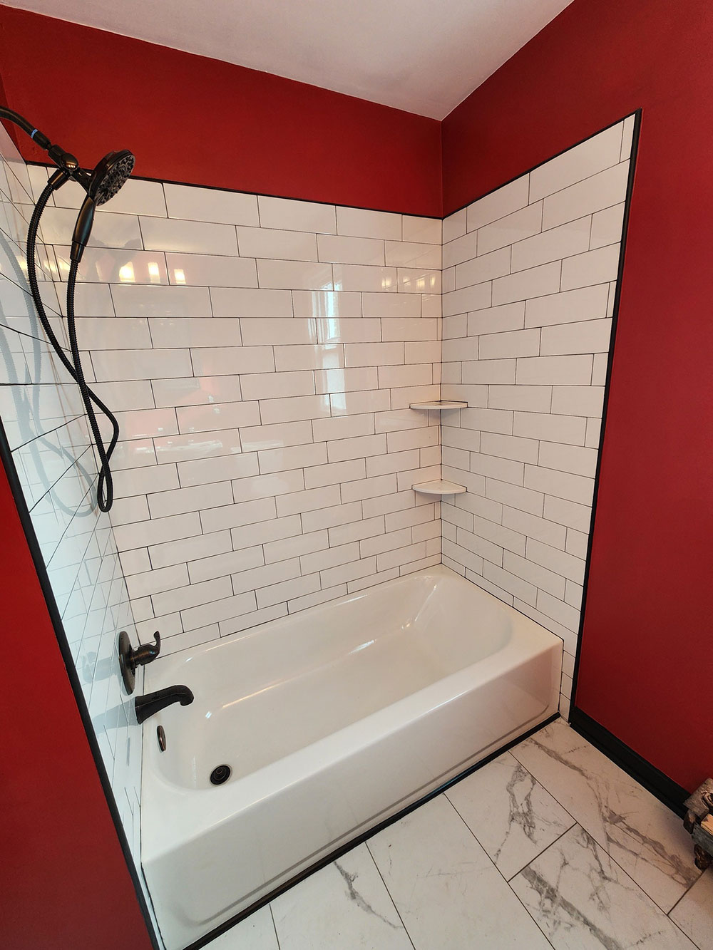 Installed a new tub with white subway tiles and black grout